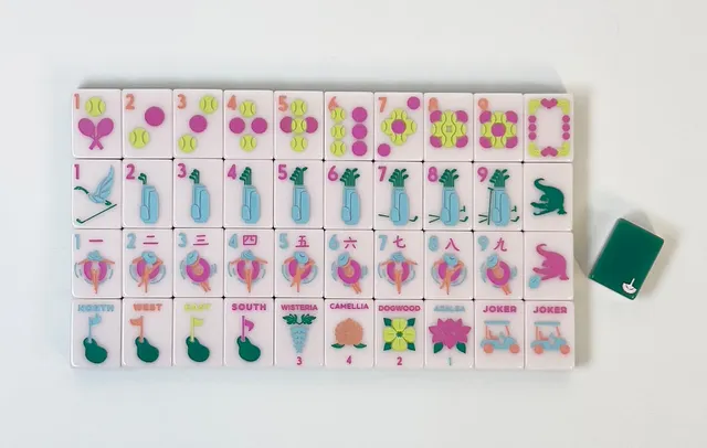 Mahjong tiles with ivory ceramic and green gold club motifs.