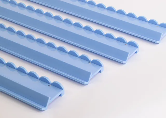 Cornflower blue scalloped acrylic rack for mahjong tiles.